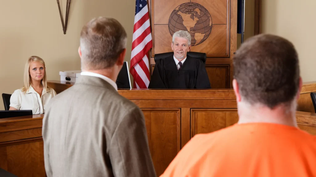 A judge in a courtroom overseeing a case with two individuals present, representing legal proceedings.